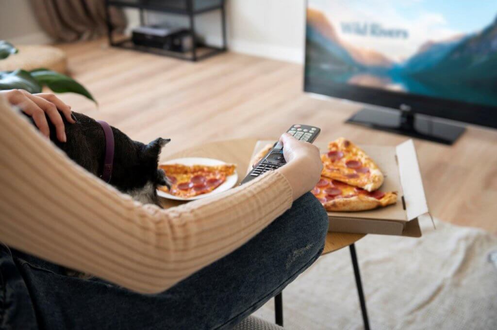 woman-eating-pizza-and-watching-tv